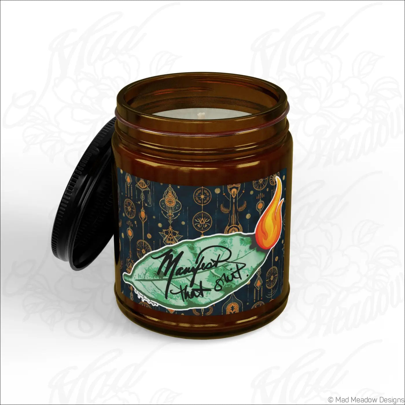 Brown glass jar soy wax candle with black lid and green leaf flame label manifest that sh!t bay leaf scent