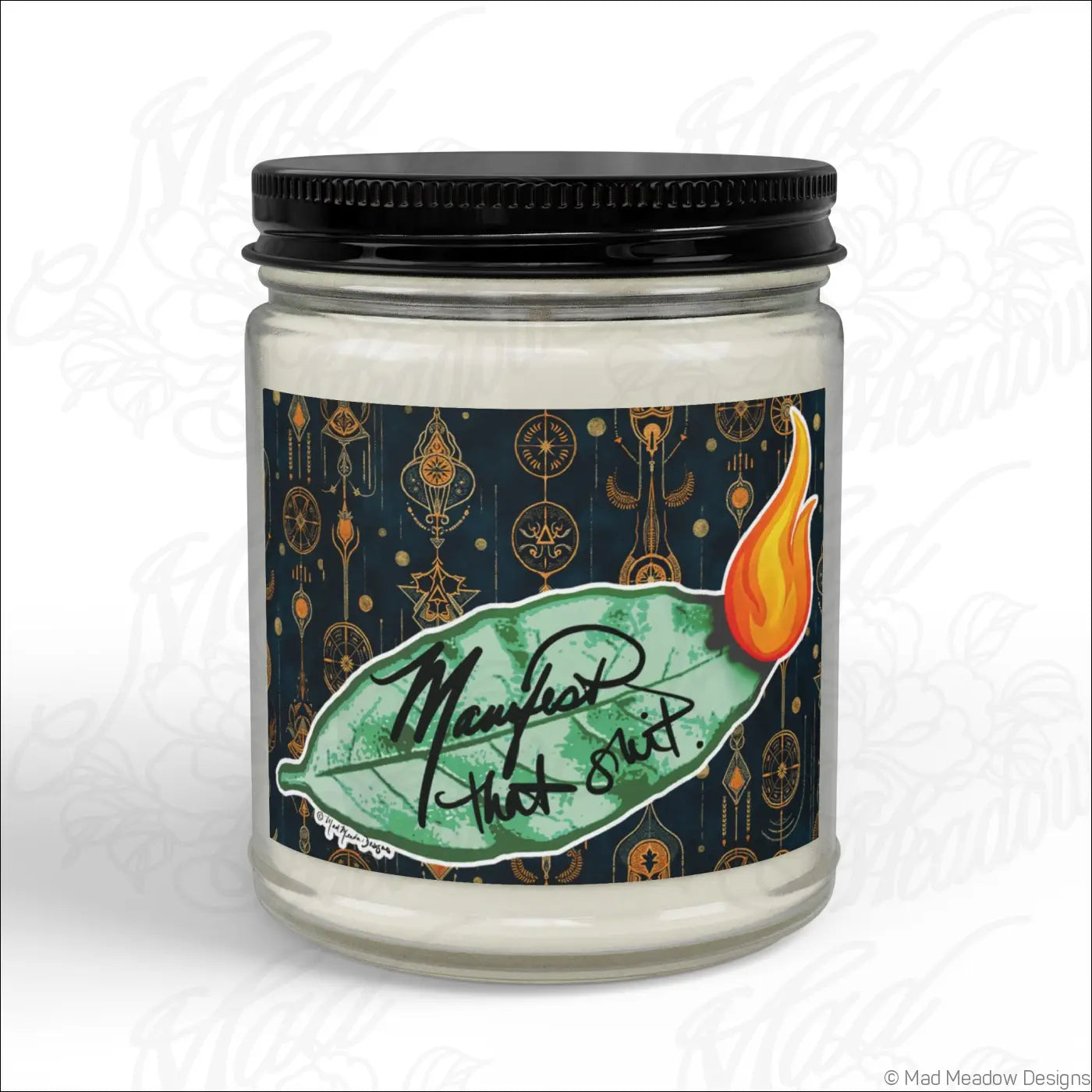 White soy wax candle in a glass jar with black lid and manifest that suit label on a green leaf design