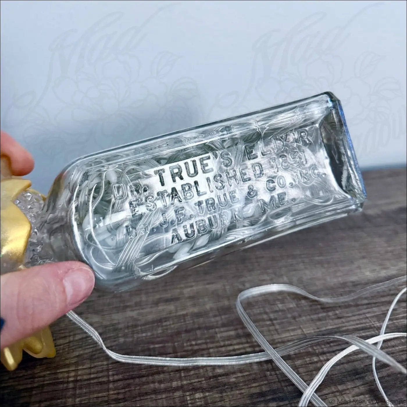 Clear glass antique glass bottle with embossed dr text on golden lotus flower base usb light