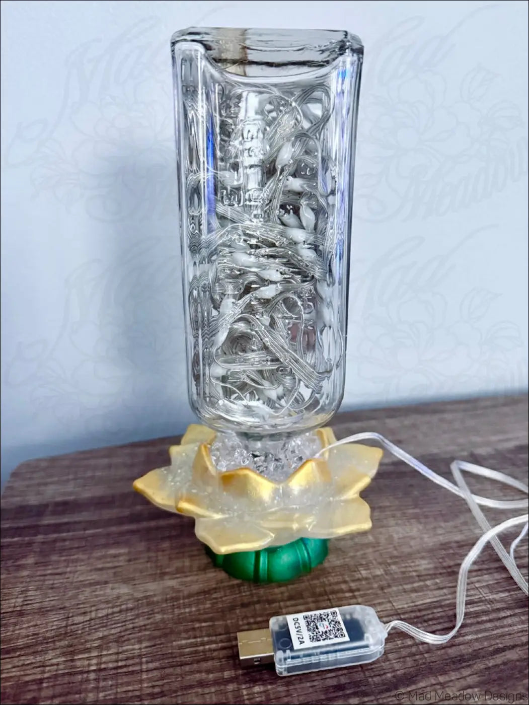 Clear glass antique glass vase with intricate wire design on golden lotus base and green pedestal usb light
