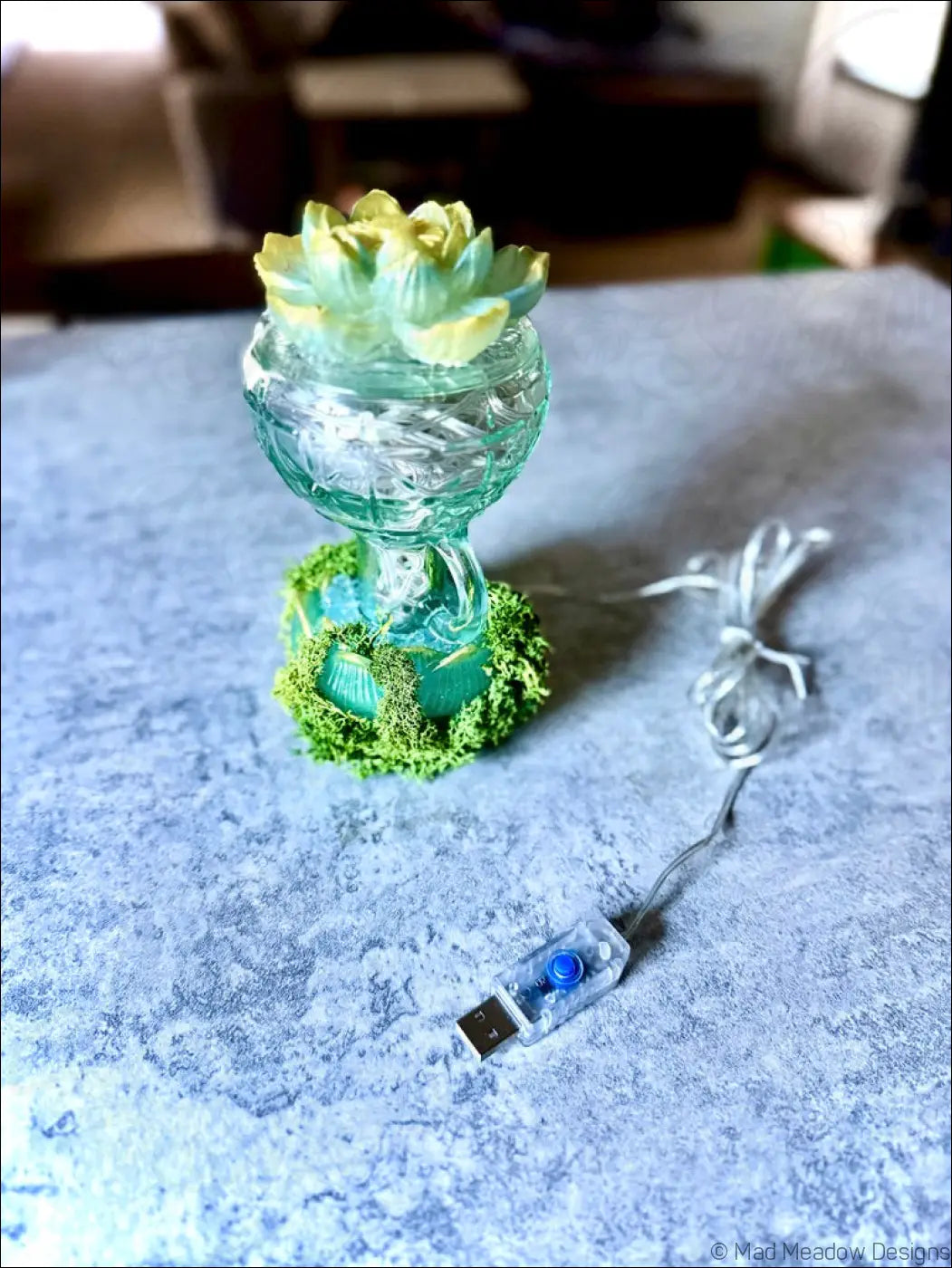 Mint green vintage glass lantern with yellow green lotus flower top surrounded by moss and white lights usb lamp