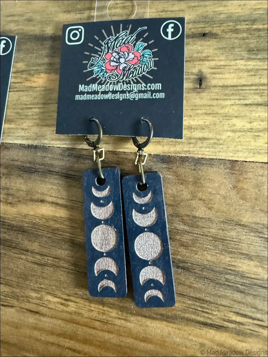 Dark blue rectangular wooden earrings with silver-toned moon phases design perfect for celestial magic lovers