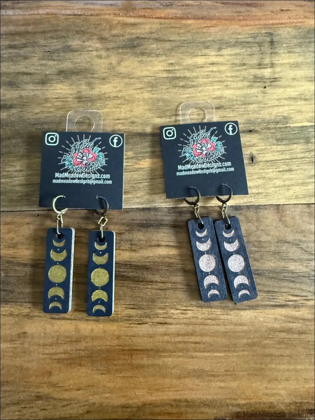 Dark blue rectangular wooden earrings hand-painted with gold and silver moon phases for celestial magic style