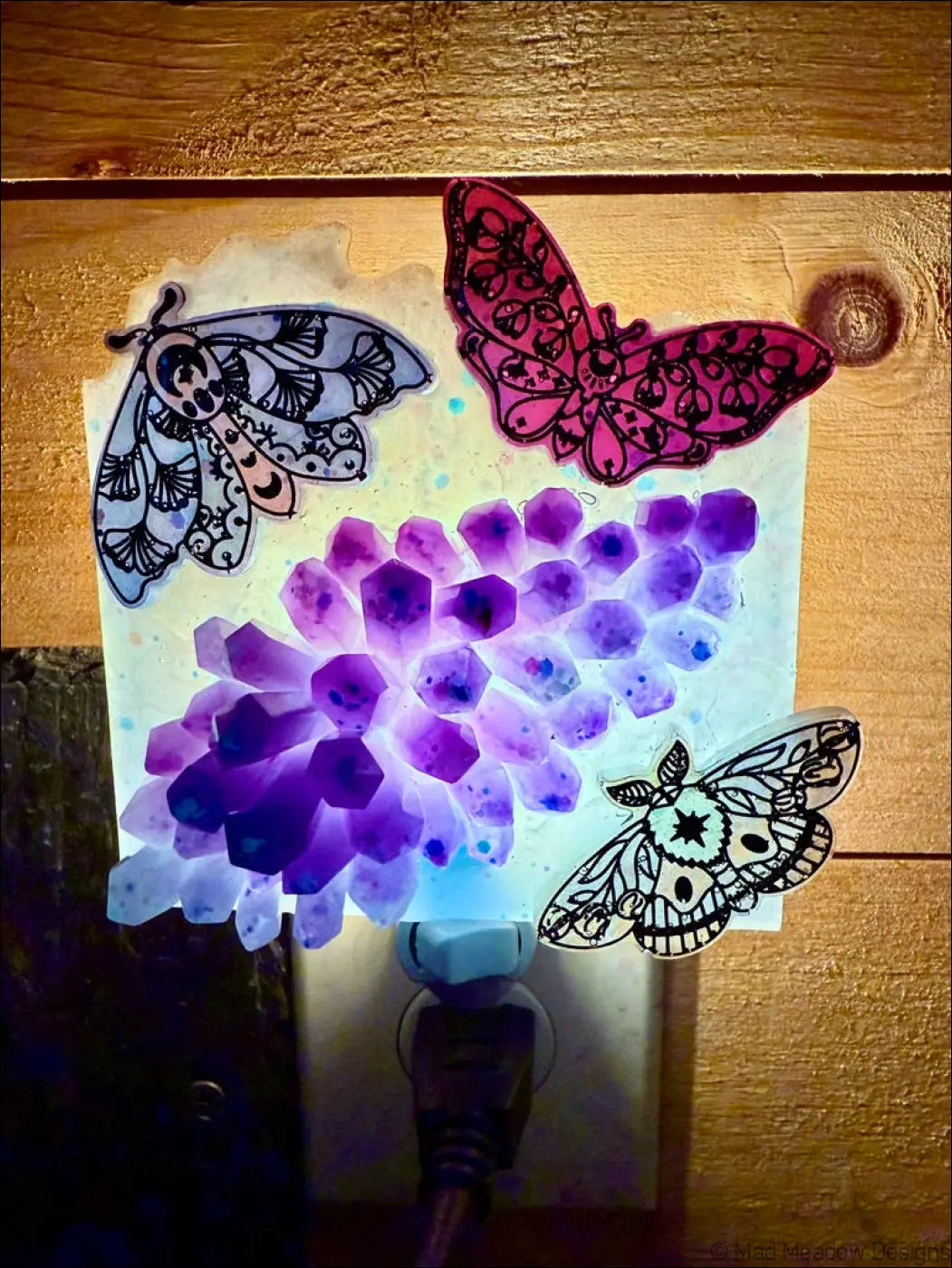 Purple and pink moths and crystal cluster wall night light with delicate iridescent moths on a soft aqua blue glow panel