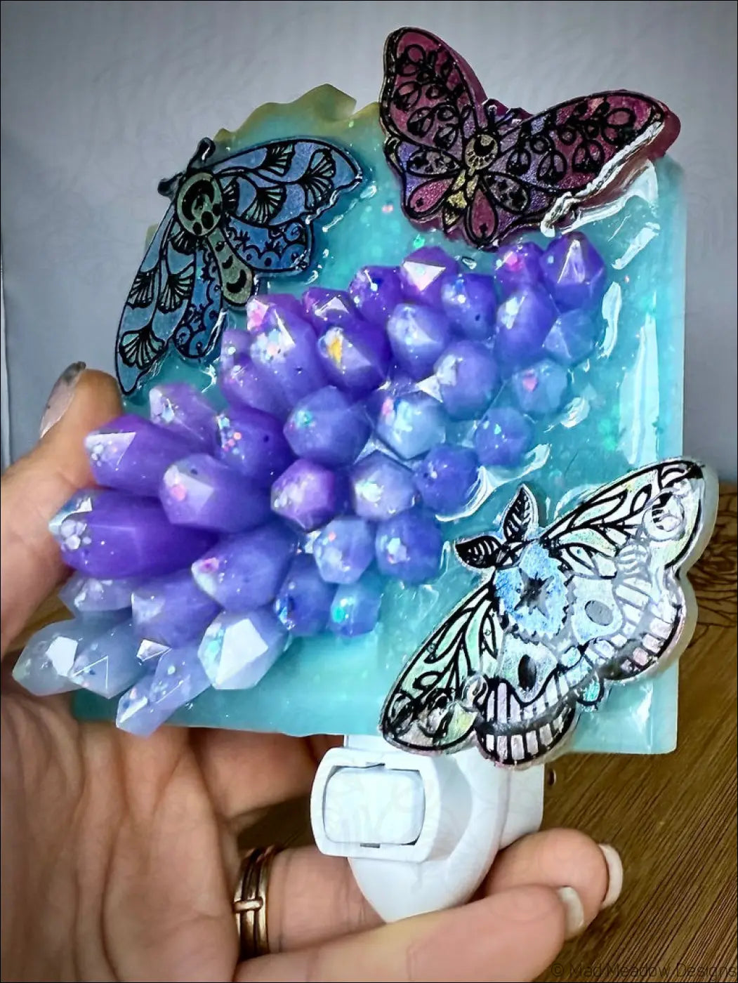 Moths and crystal cluster wall night light with a mesmerizing crystal cluster and delicate iridescent moths on soft aqua blue base