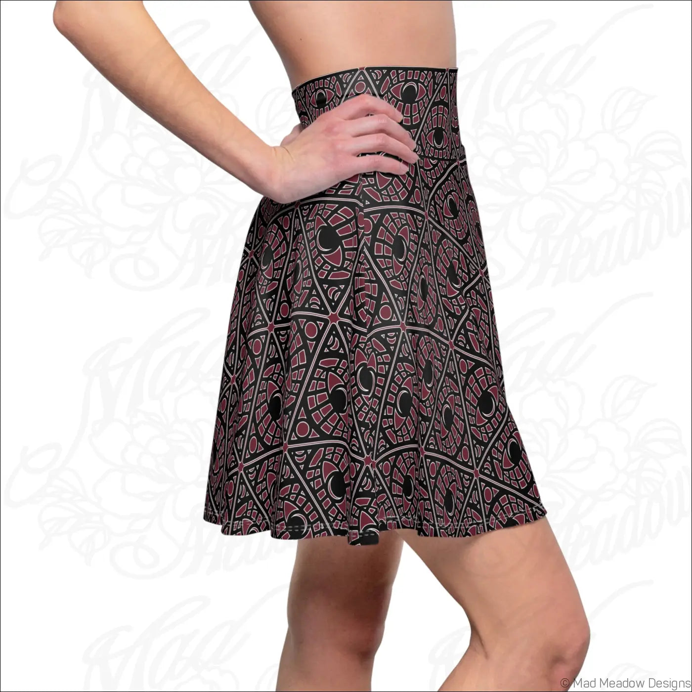 A black mystic eye tribal pattern skater skirt in stretch fabric with bold maroon and white shapes and a printed care label