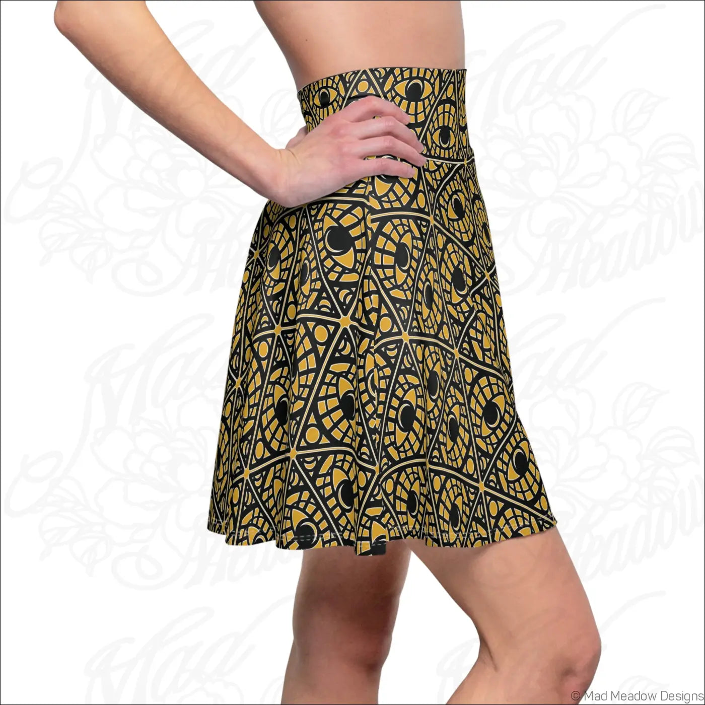 Mustard skater skirt with bold black and gold geometric eye print made from stretchy fabric with printed care label