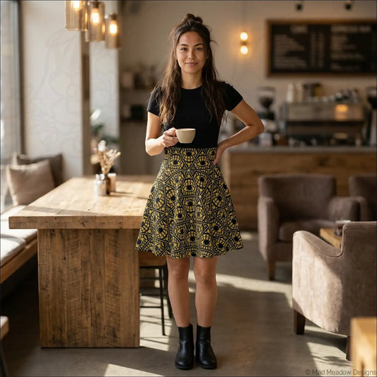 Black and gold geometric printed skater skirt with stretch fabric and flared hem featuring a printed care label