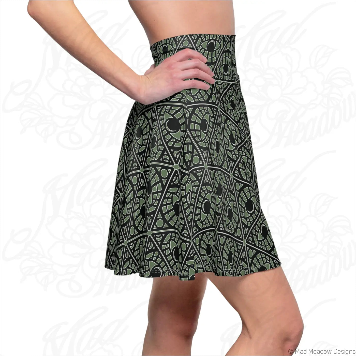 A dark green high-waisted skater skirt with a black and gray geometric print and stretch fabric featuring a printed care label