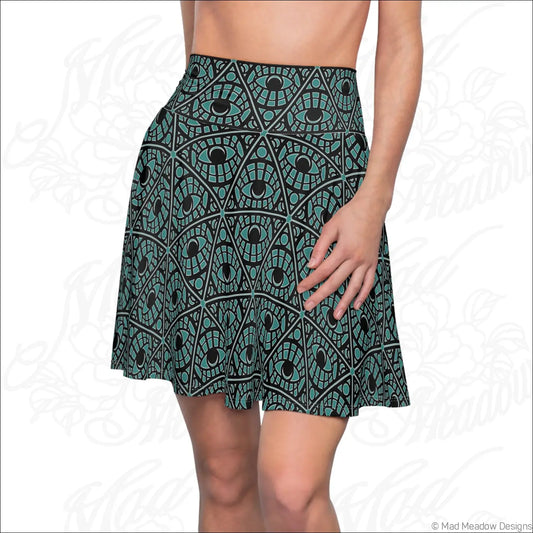 A teal skater skirt with a mystic eye tribal pattern in stretch fabric featuring a printed care label
