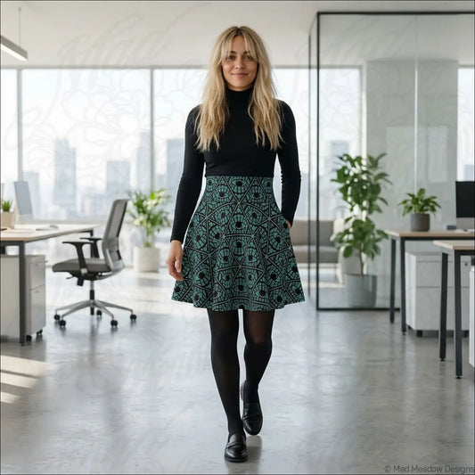 A teal and black geometric printed skater skirt with stretch fabric worn over a black turtleneck with printed care label
