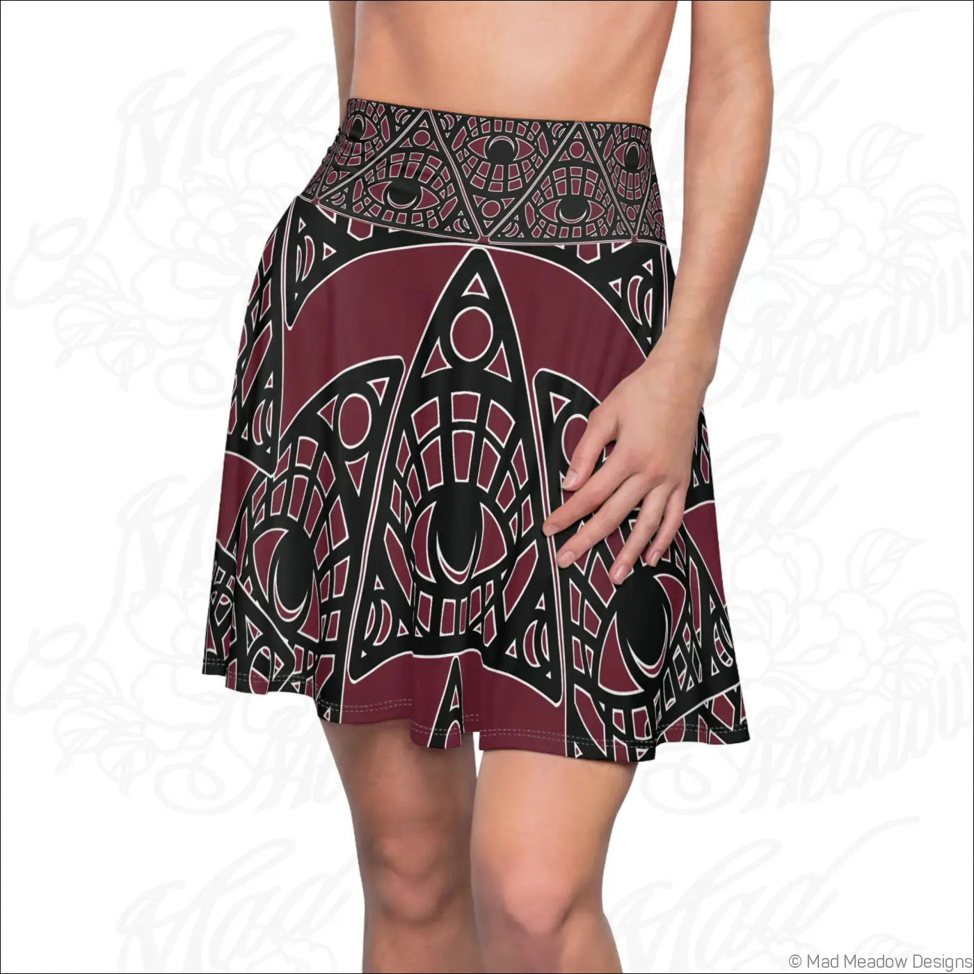 Maroon and black geometric printed skater skirt with eye motifs and stretch fabric featuring a printed care label