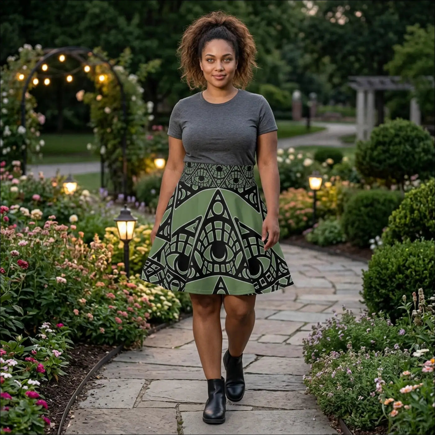 A woman wears a sage allover print mystic eye tribal skater skirt with stretch fabric and a printed care label