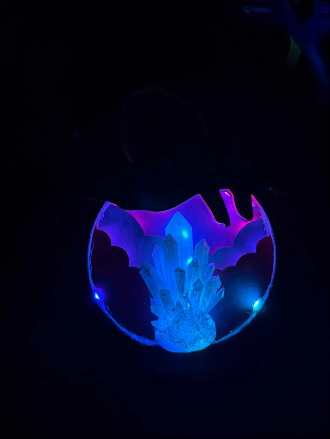 Glowing blue and purple crystal pendant with translucent bat-shaped frame in enchanting laser-cut wood hanging crystal ball design