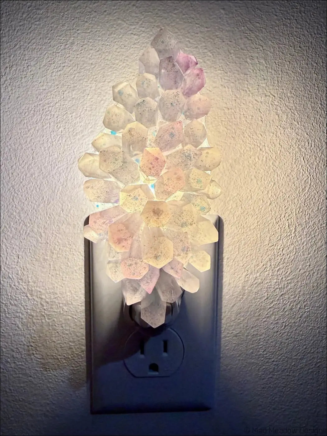 Pastel translucent white and purple crystal cluster resin wall night light with soft pink hues on plug-in base, perfect for feather wall night decor