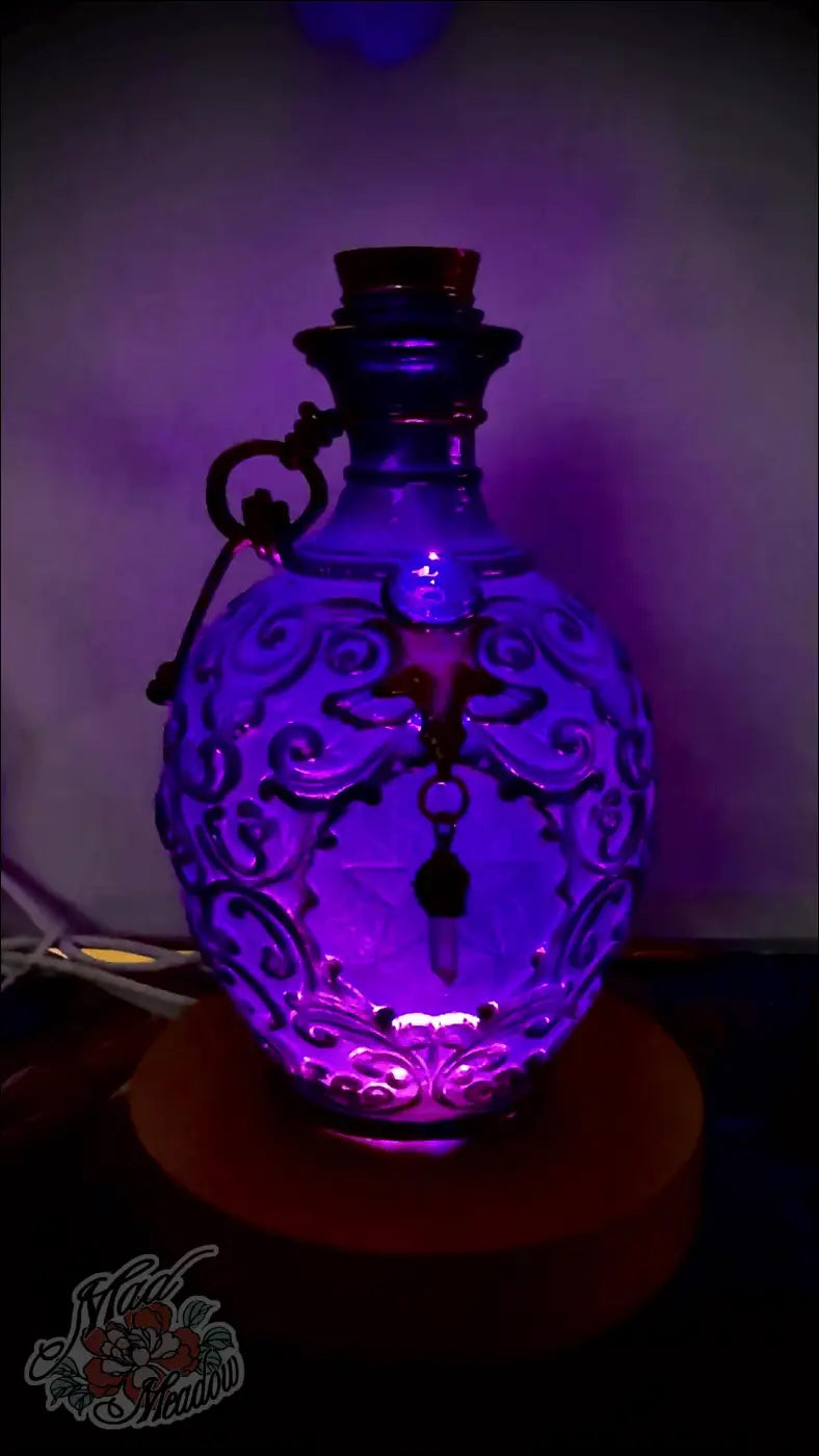 Purple glass potion bottle light with crystal dangles featuring etched swirls cork stopper and metal key charm