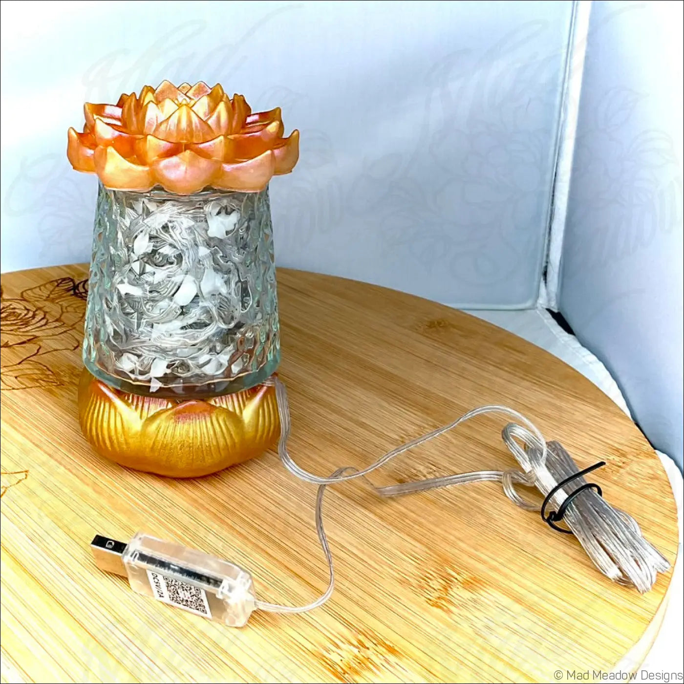 Ornate orange and gold lotus flower shaped glass diffuser with intricate carvings in a red pink and gold app controlled usb light