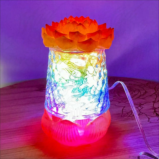 A glowing lotus flower glass lamp with orange top pink base in red pink gold resin app controlled usb light