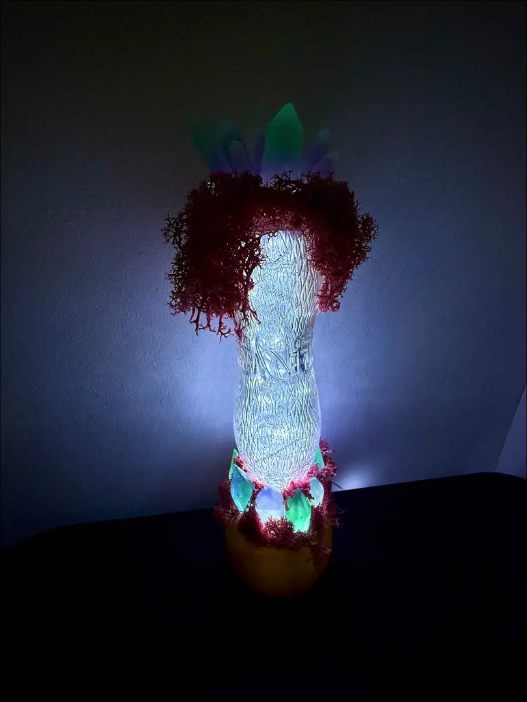A glowing translucent glass lamp with red moss accents inspired by 1920s hourglass whistle soda vintage design