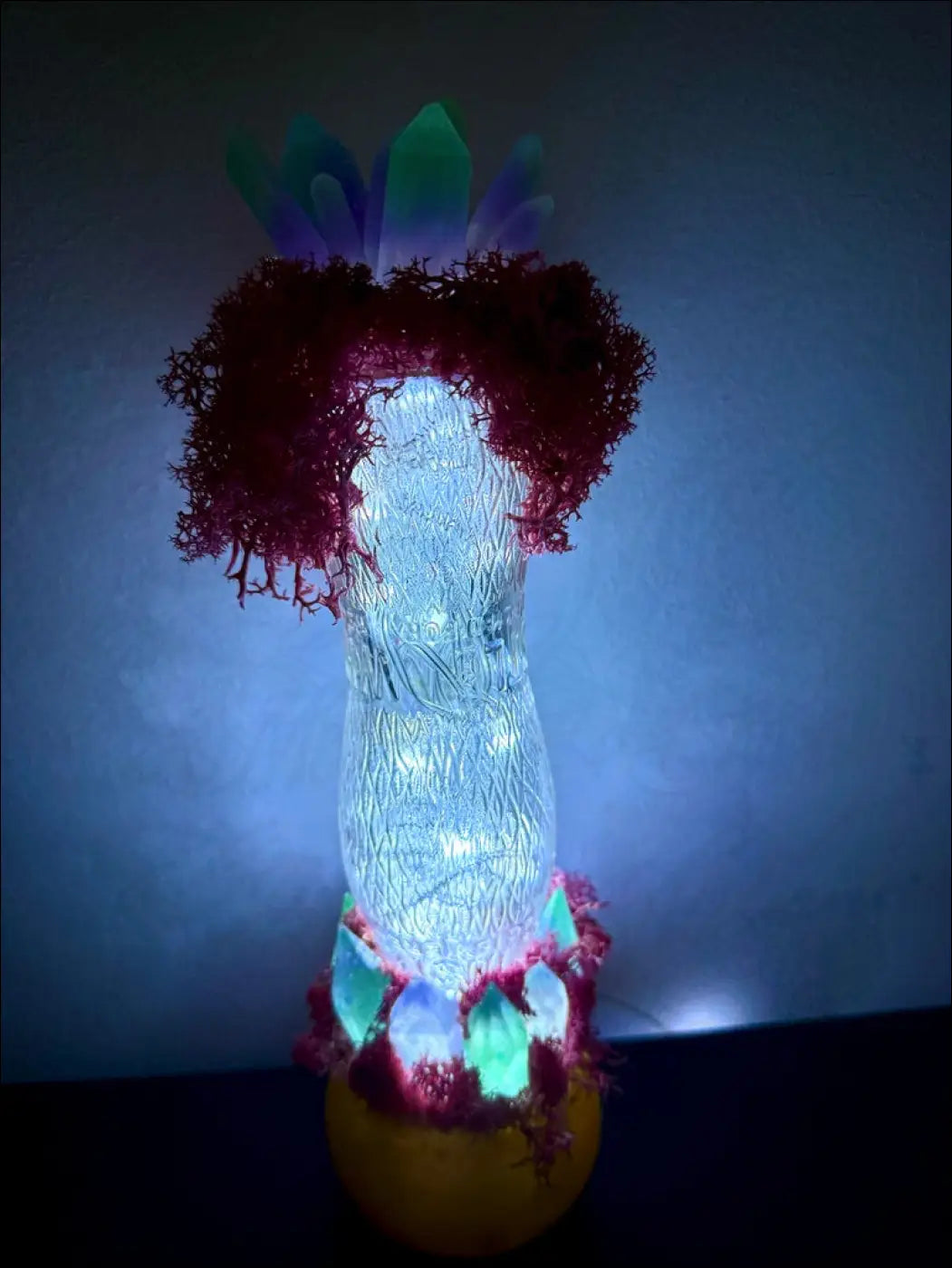 A glowing jellyfish-shaped resin lamp with red coral fronds and green crystals inspired by 1920s hourglass whistle vintage