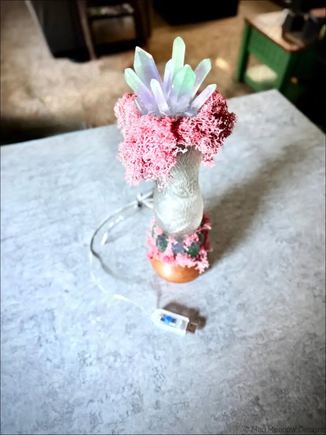 A decorative resin crystal lamp with pink moss and translucent faceted top perfect for 1920s hourglass whistle soda decor