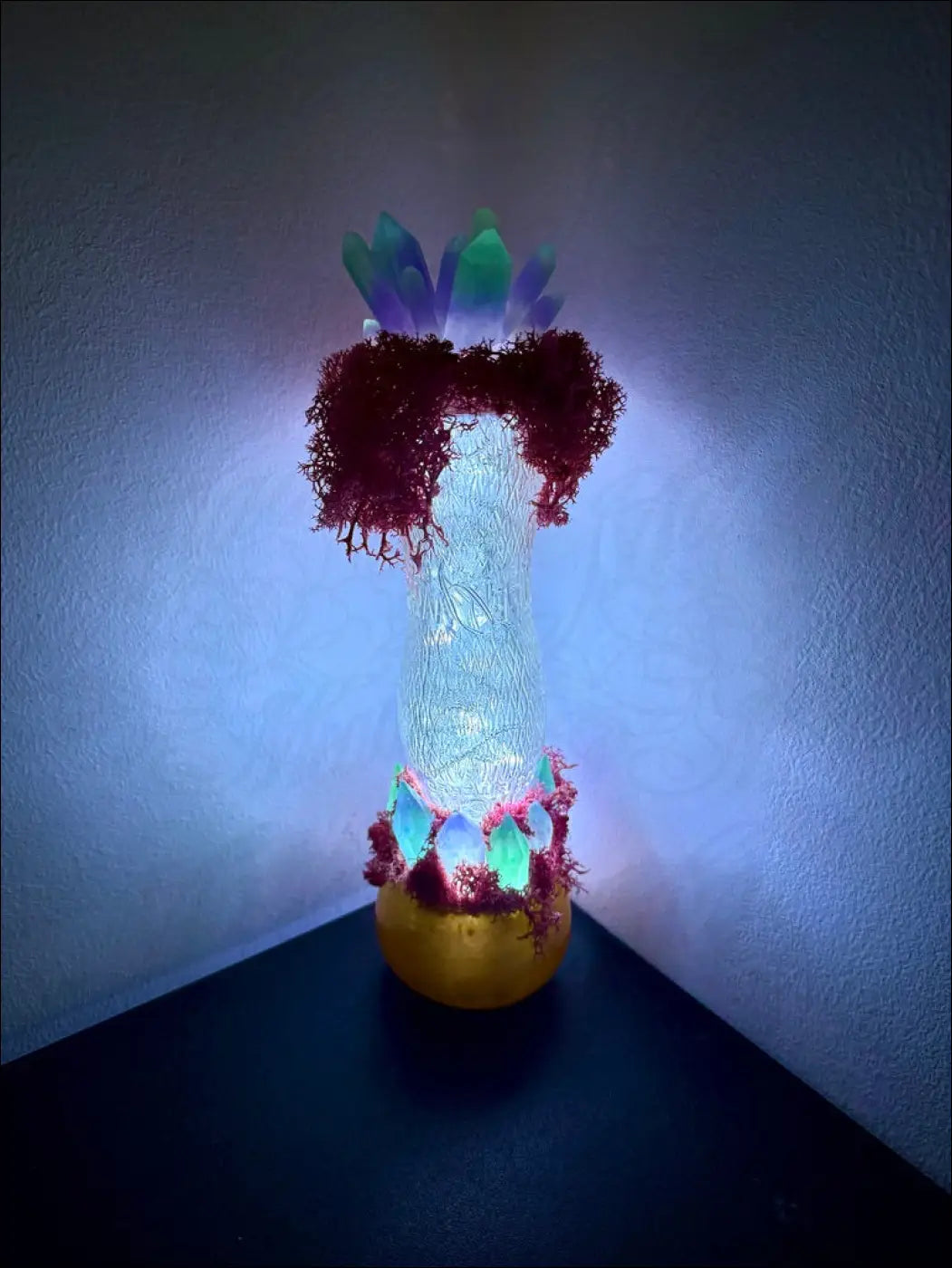 A glowing white resin vase lamp with red moss and colorful crystals inspired by 1920s hourglass whistle soda vintage design