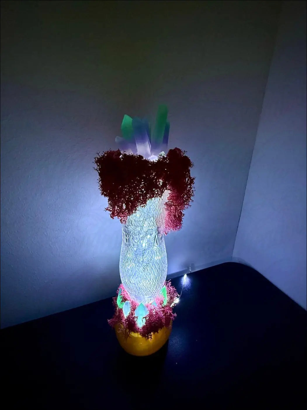 A glowing translucent resin crystal vase with red pink moss textures inspired by 1920s hourglass whistle vintage style