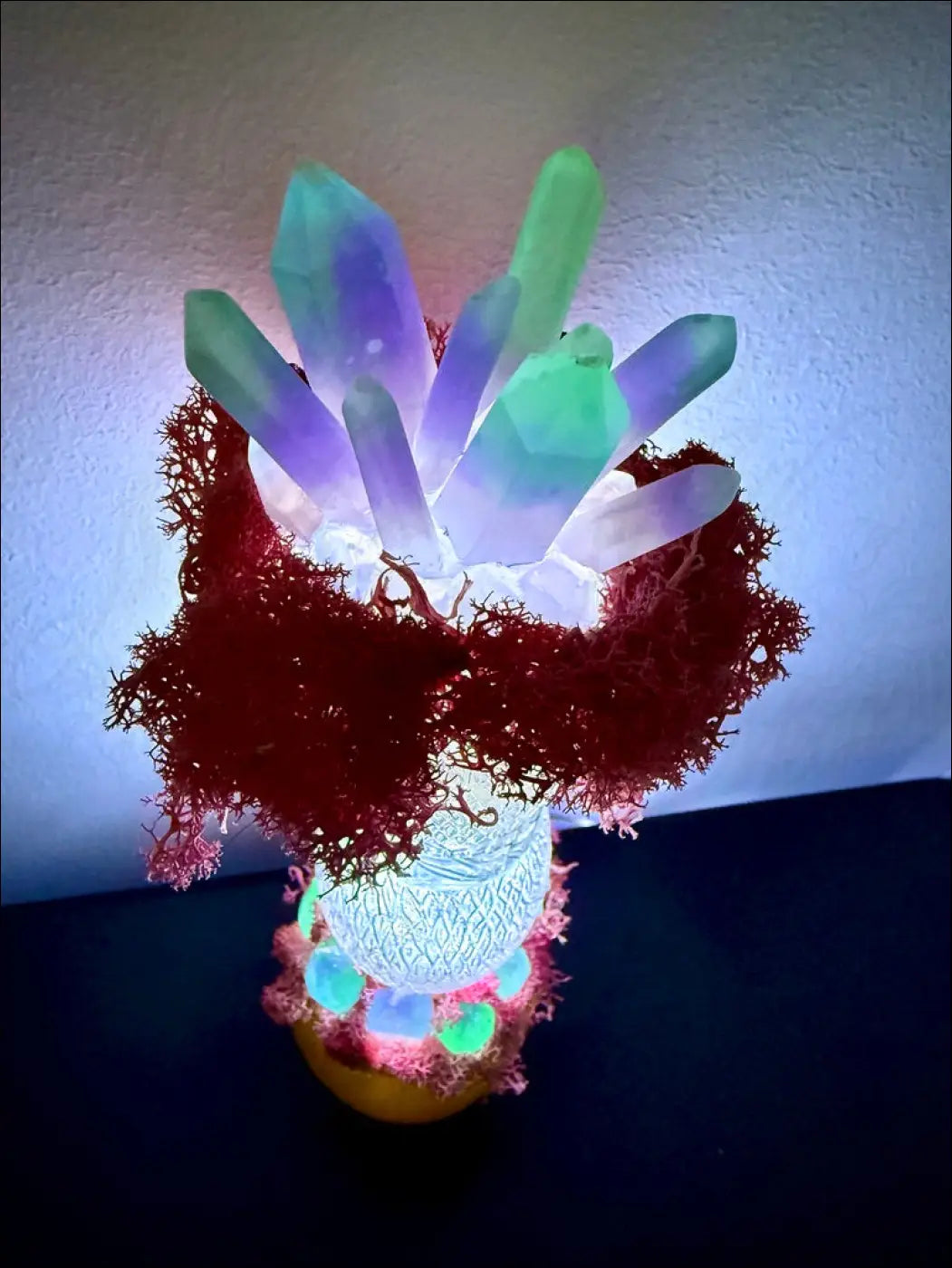 A glowing resin crystal lamp with vibrant red moss and textured base inspired by 1920s hourglass whistle vintage design