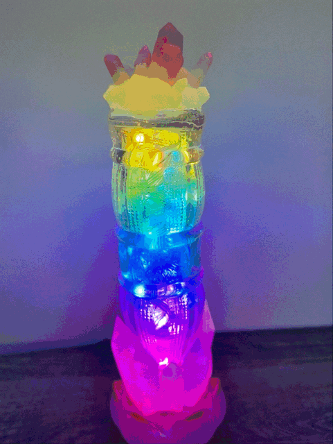 A vibrant multi-colored led-lit tiki torch with a translucent body glowing rainbow hues in 1940s sunset beverage style