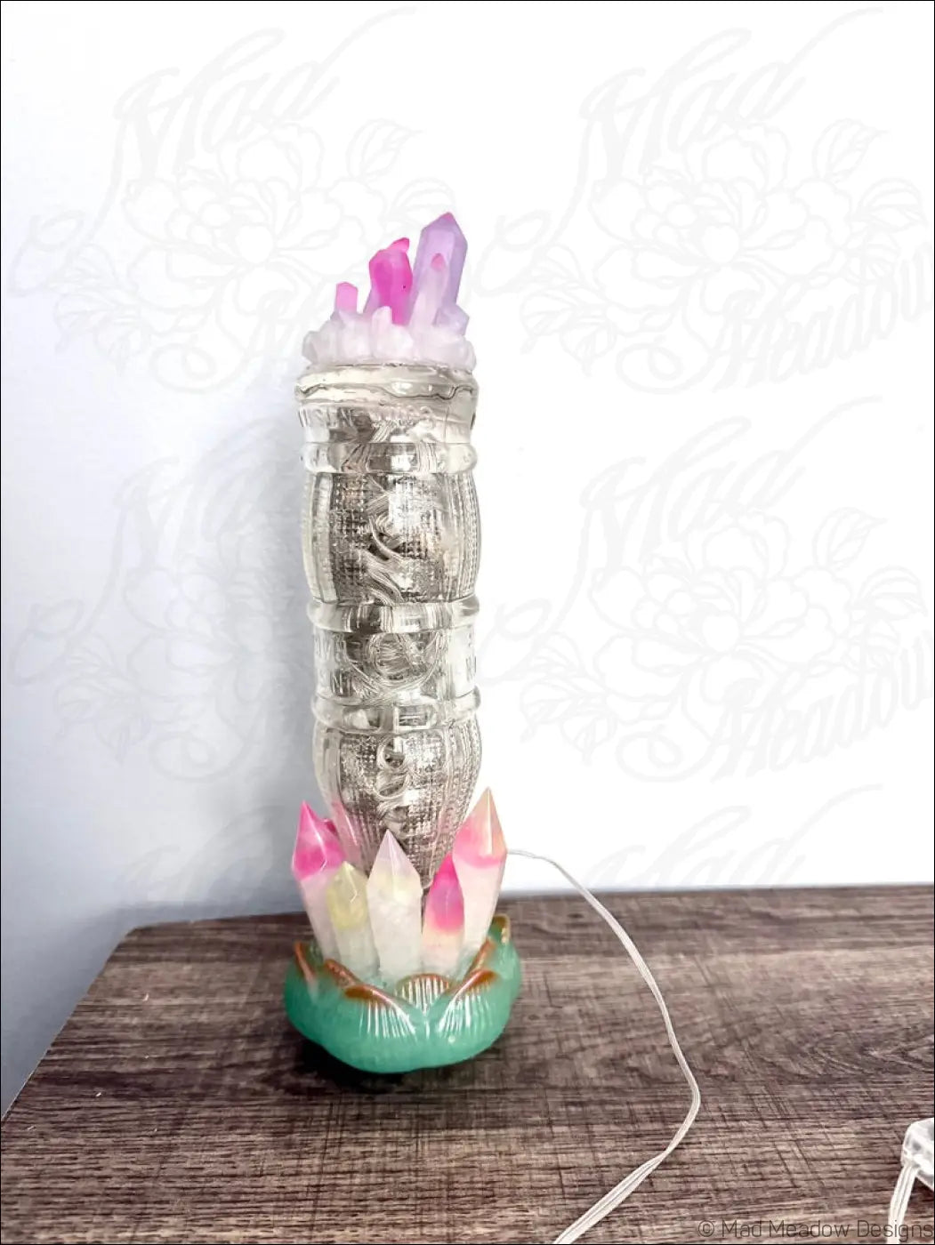 A translucent glass money tower with lotus flower base and pink white resin crystals inspired by 1940s sunset beverage