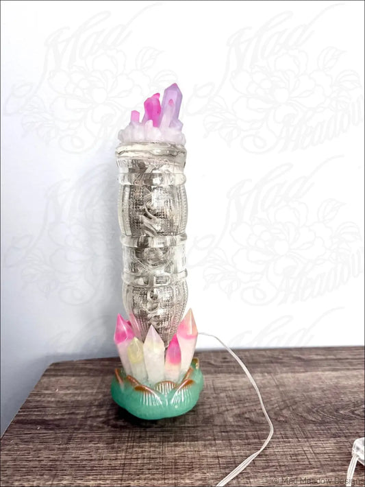 A translucent glass money tower with lotus flower base and pink white resin crystals inspired by 1940s sunset beverage