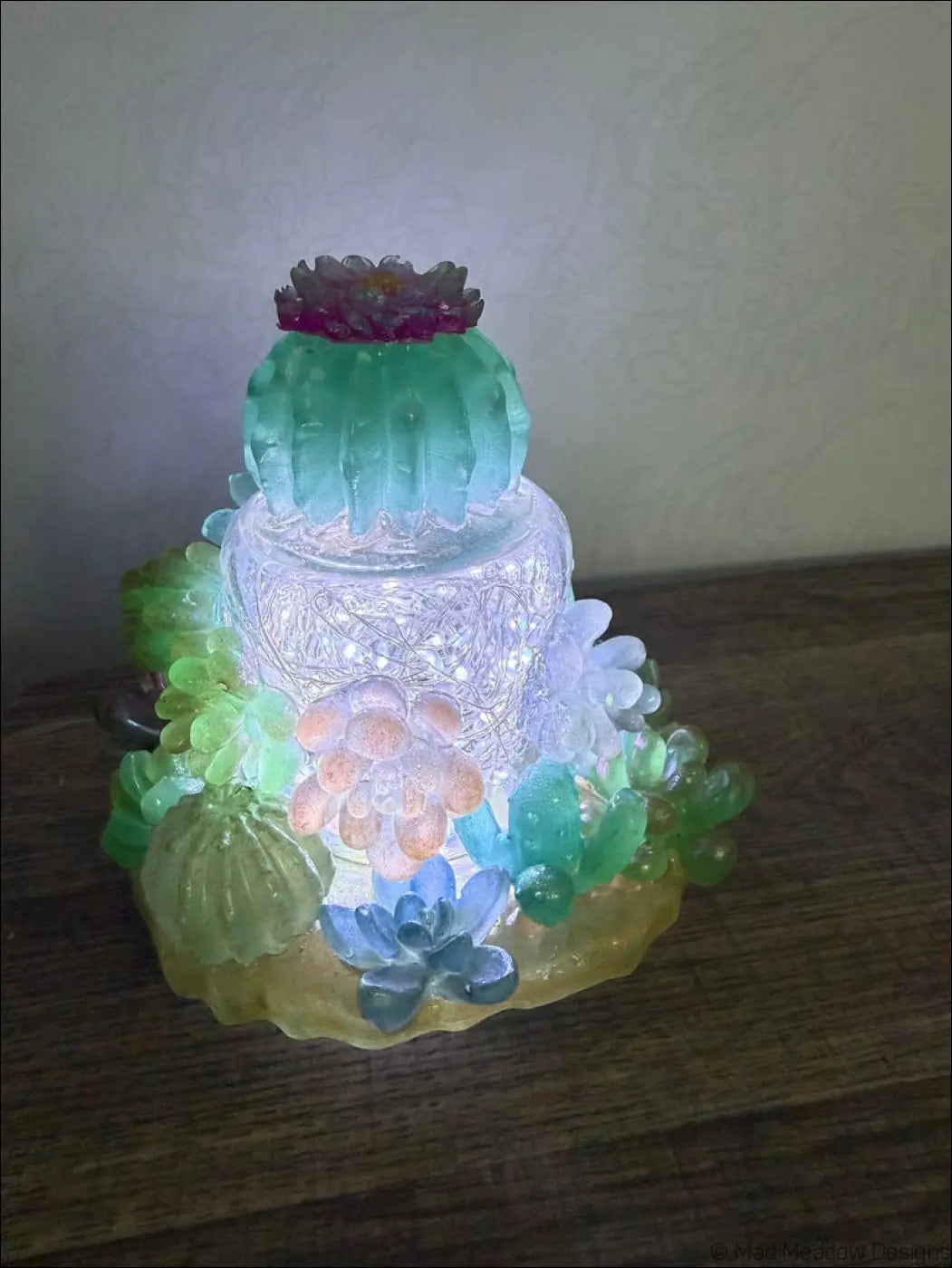 A usb powered resin succulent garden light with glowing central tier and colorful succulent and cactus figurines