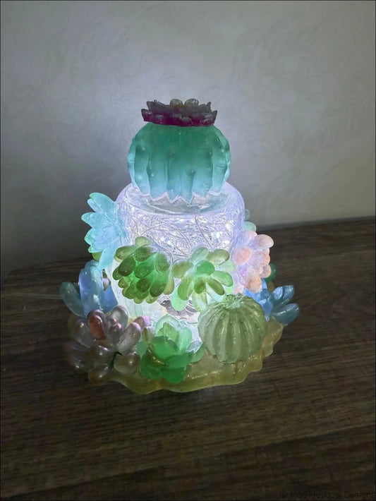 Resin succulent garden light with a translucent multi-tiered cactus design featuring glowing green and blue accents