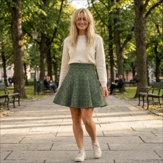 A sage green skater skirt with pleats and a geometric elemental column pattern easy to care for and line dry