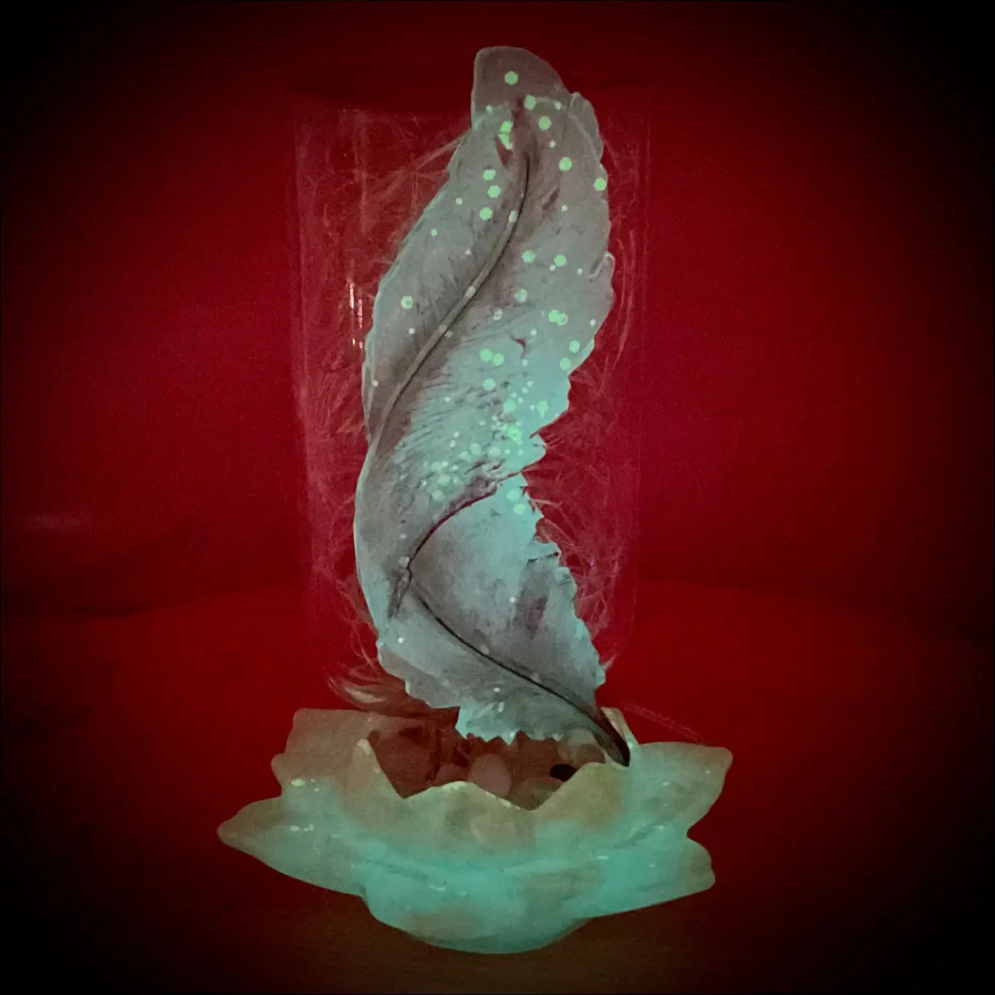 Silver feather sculpture with glowing dots in a clear antique glass apothecary bottle on teal lotus flower base usb light