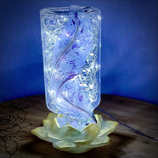 A translucent antique glass apothecary bottle with swirling design and fairy lights on a yellow lotus flower base