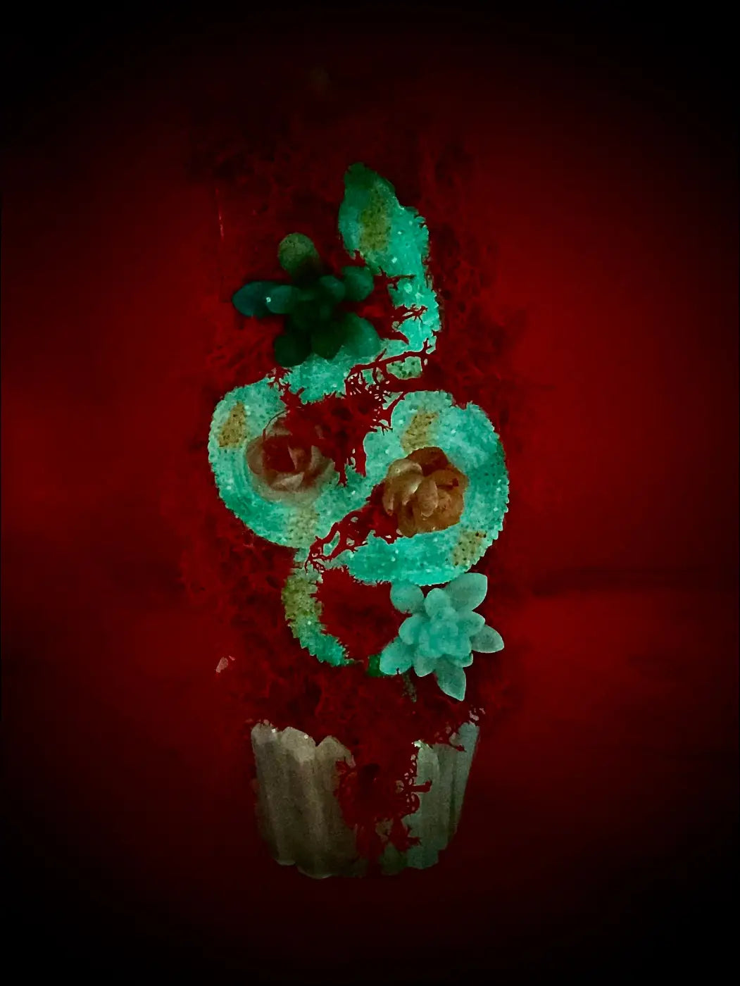 A turquoise sugar skull cupcake with edible flowers and glittery details on a pastel purple moss apothecary bottle usb light