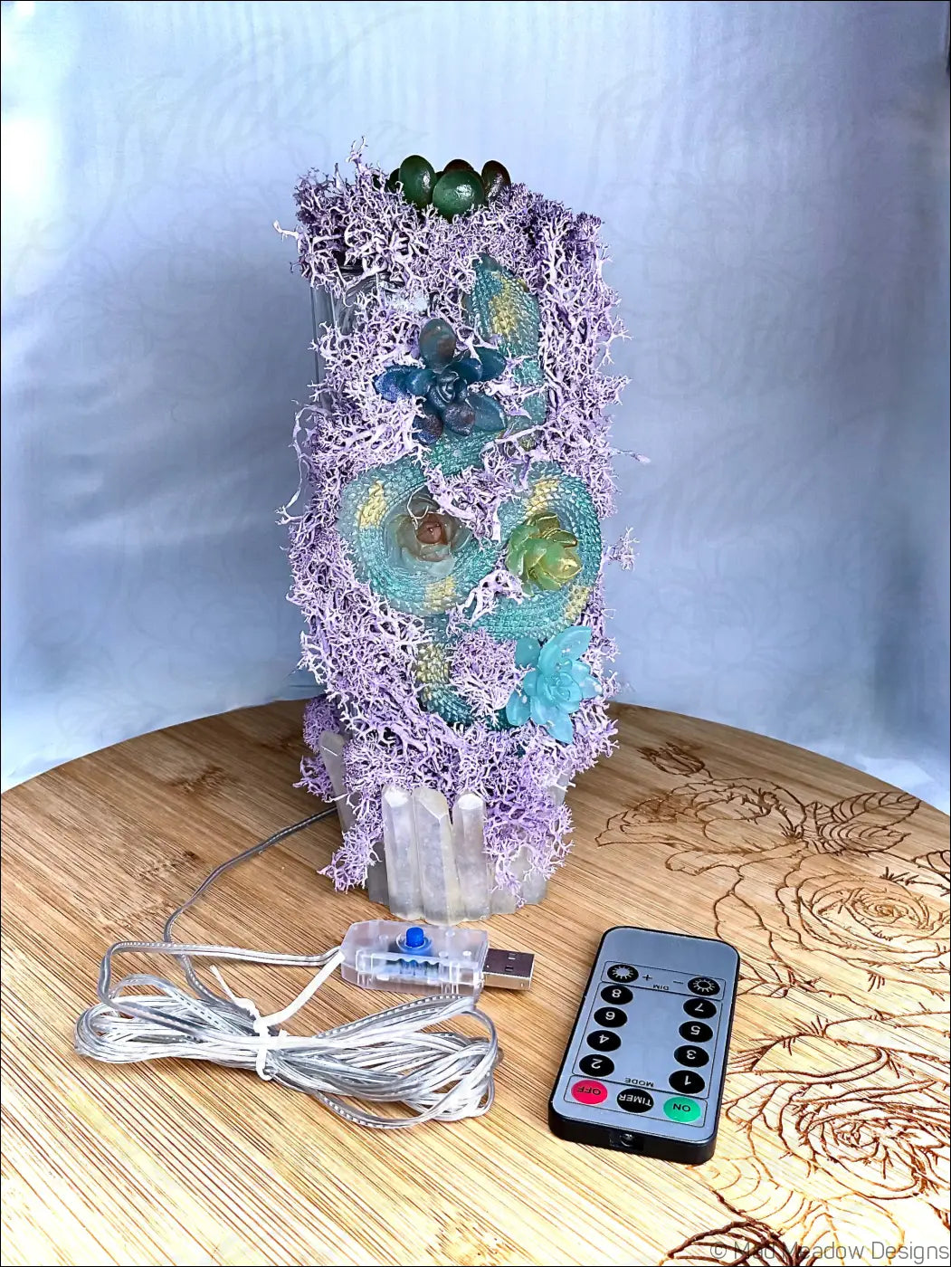 A pastel purple resin lamp with purple moss, teal succulents, crystals, and a usb light remote control