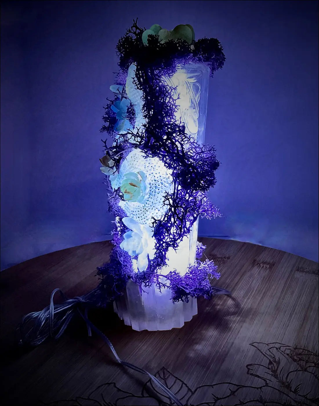 A glowing usb light with pastel purple moss and crystals in an antique glass apothecary bottle lamp