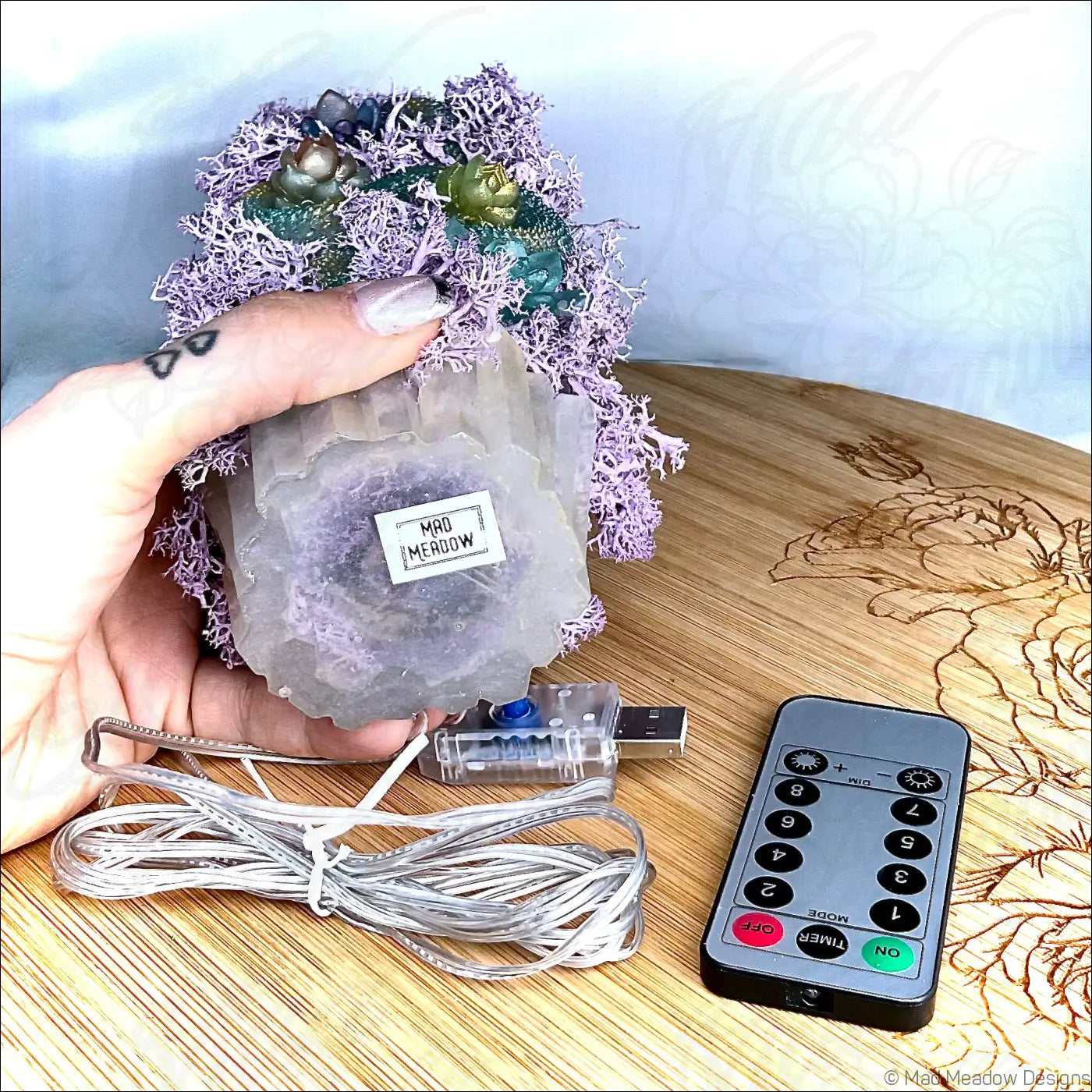 A whimsical purple crystal lamp with pastel purple moss and green gemstones on an antique glass apothecary bottle usb light