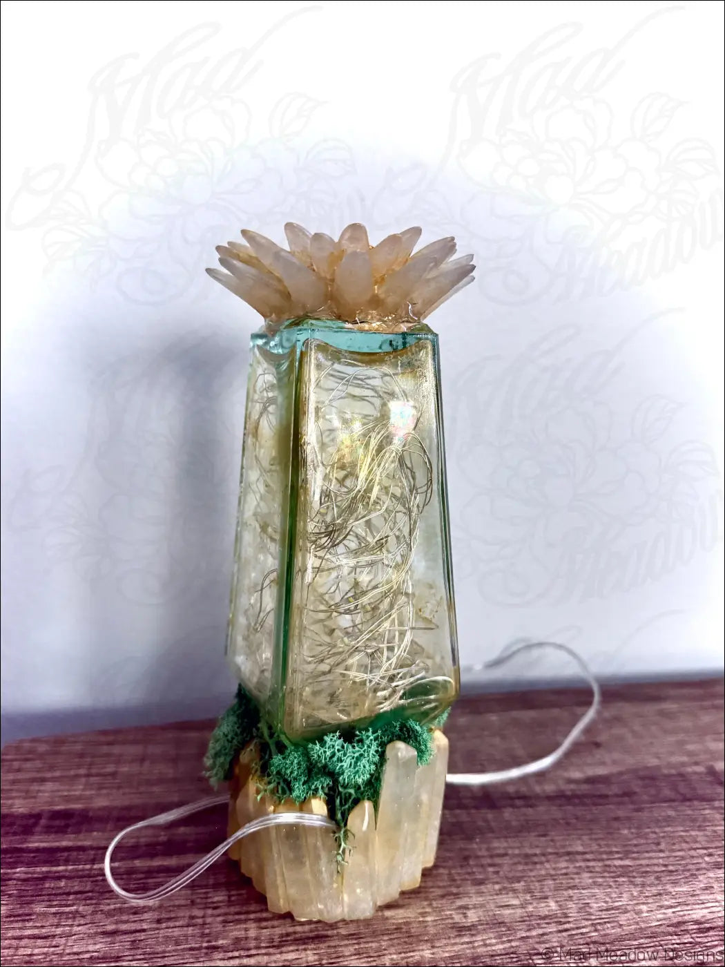 A translucent glass hair petrole bottle lantern with frosted petal top and green moss base usb light with crystals