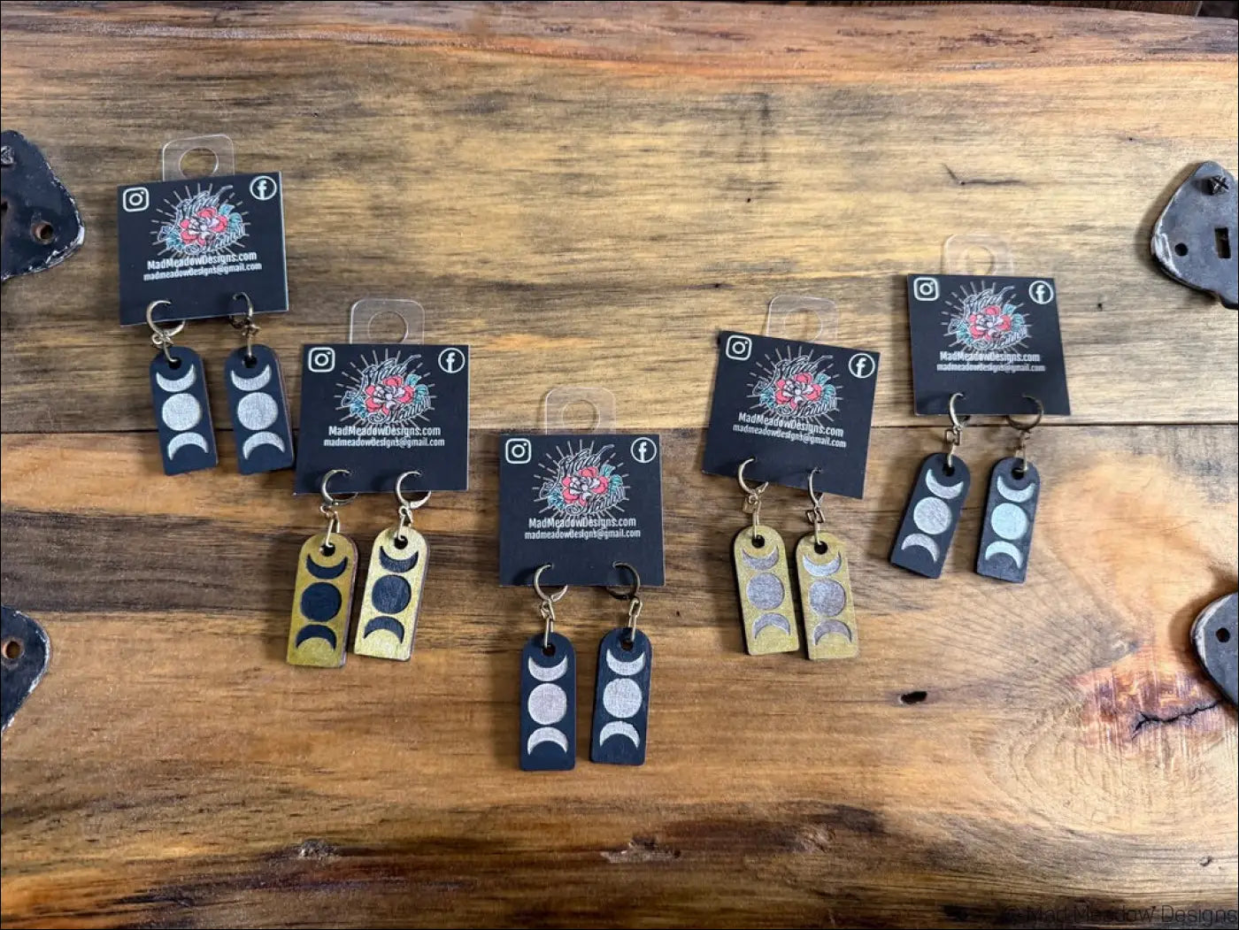Triple moon wooden earrings in black and gold with silver foil detailing and hand-painted moon phases