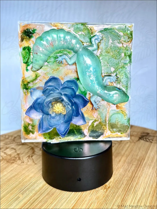 Translucent teal captivating gecko and blue water lily resin nightlight on black base with rgb color change glow