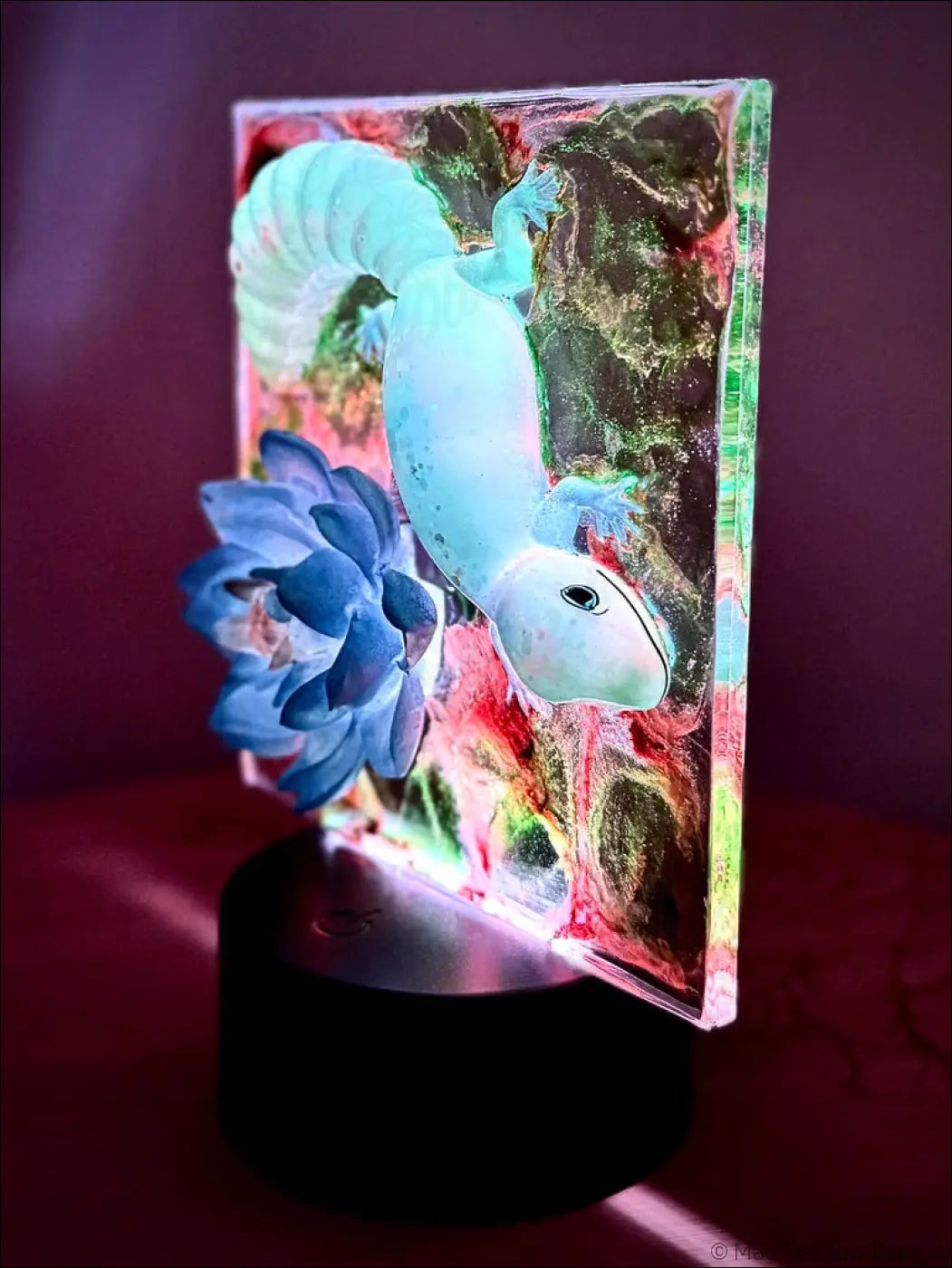 A translucent glowing blue salamander figurine in resin with colorful flowers for a captivating gecko water lily nightlight