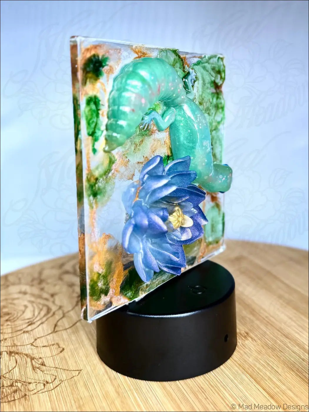 Translucent green resin night light with a captivating gecko, blue water lily, and leafy background for dreamy decor