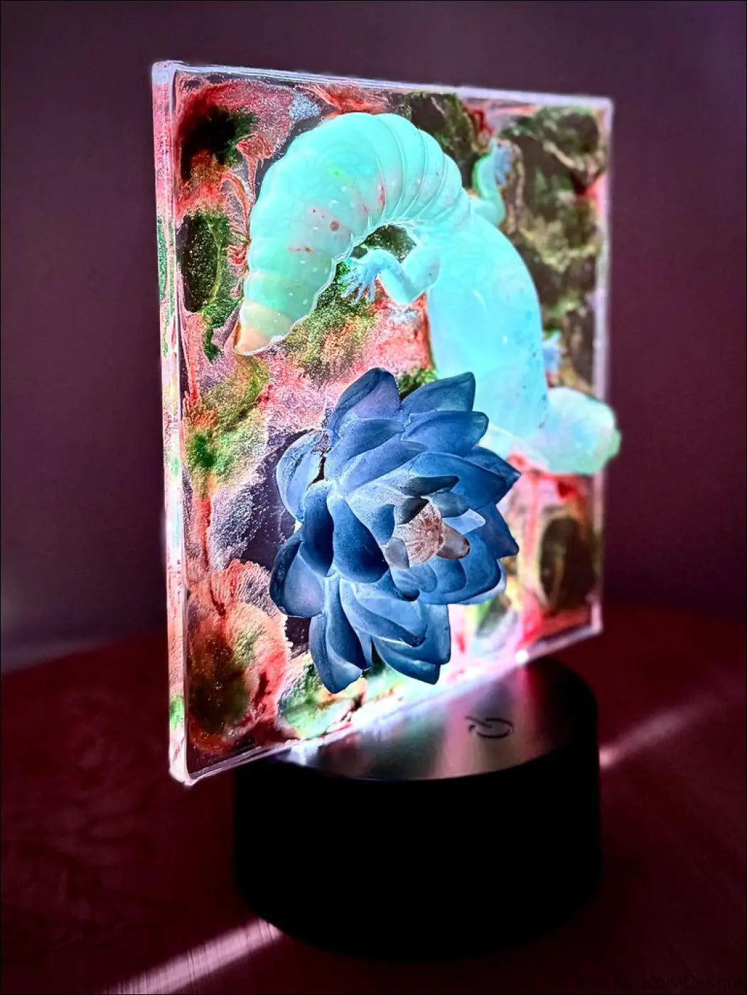 A captivating gecko and blue water lily nightlight with a glowing caterpillar and succulent resin sculpture on black base