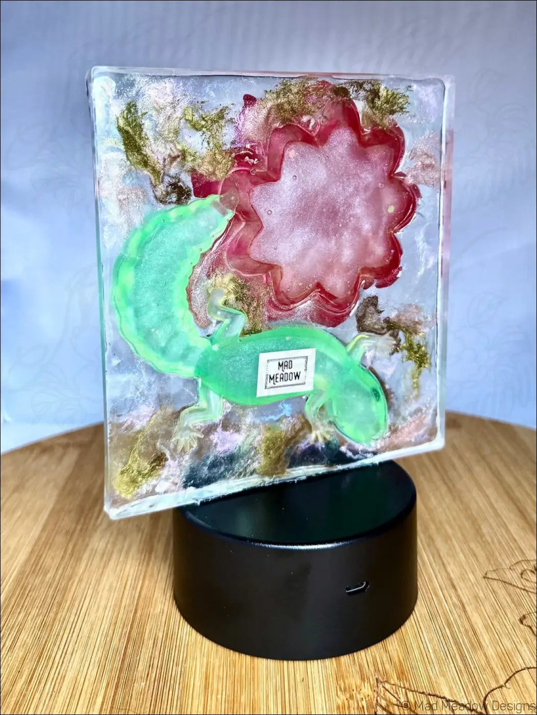 Whimsical glowing gecko night light with translucent resin, warm golden leaf, glowing green salamander, and vibrant crimson bloom