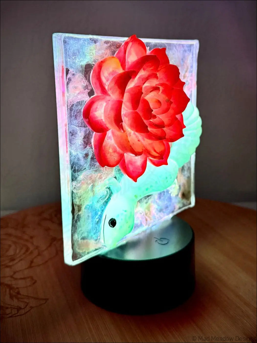 Whimsical glowing gecko night light with a vibrant crimson bloom and warm golden glow on a green glass base