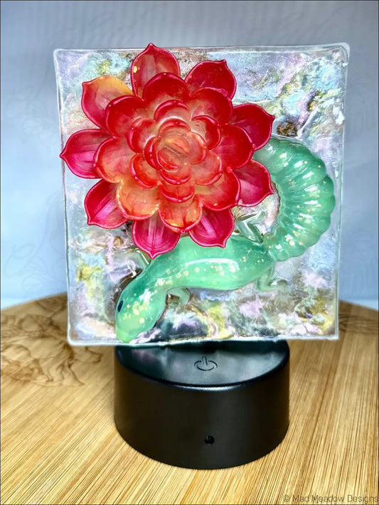 A whimsical glowing gecko on vibrant crimson bloom glass succulent in a warm golden rgb color change night light