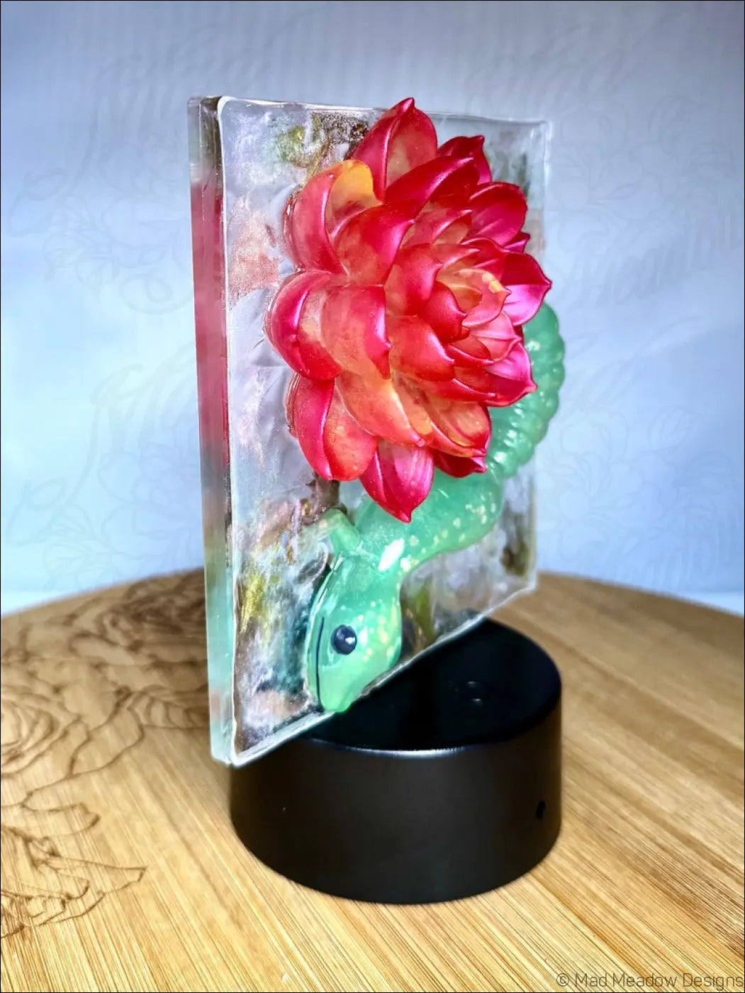 Whimsical glowing gecko night light with a vibrant crimson bloom resin flower on a black stand and warm golden rgb colors